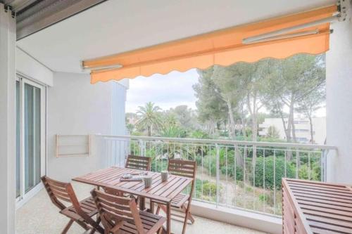un balcon avec une table et des chaises et une grande fenêtre dans l'établissement Spacious apartment with pool near the sea, à Saint-Raphaël