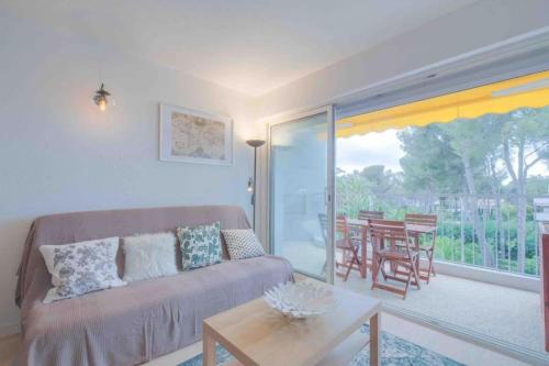 un salon avec un canapé et une table dans l'établissement Spacious apartment with pool near the sea, à Saint-Raphaël