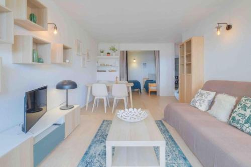 un salon avec un canapé et une table dans l'établissement Spacious apartment with pool near the sea, à Saint-Raphaël