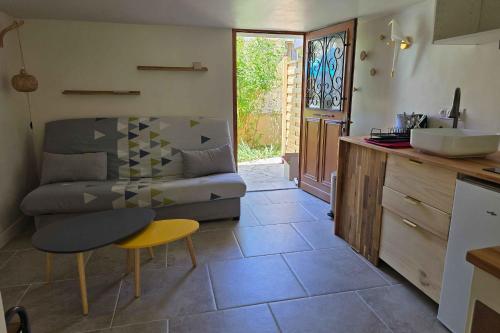une cuisine et un salon avec un canapé et une table dans l'établissement Charming studio near Nîmes center train station, à Nîmes