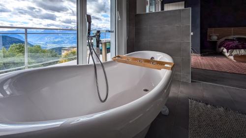 a bath tub in a bathroom with a window at Vermont Hub for Offsites, Retreats & Individual Bookings in Alps in Leysin
