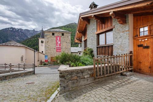 a building with a wooden door on a street at La Vieille Cloche in Saint-Rhémy-en-bosses