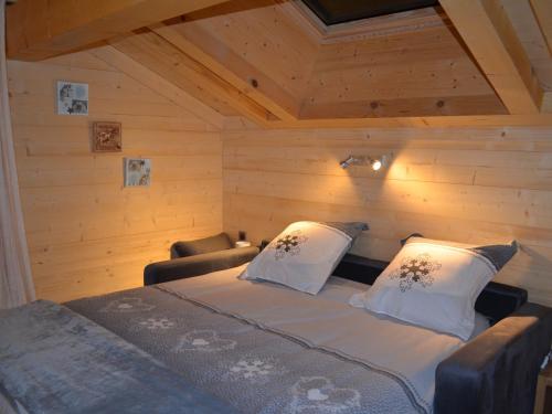 ein Schlafzimmer mit einem Bett mit zwei Kissen in der Unterkunft Chalet moderne 5 étoiles pour 10 pers. avec parking privé - FR-1-467-93 in Le Grand-Bornand