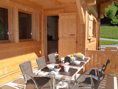 - une table et des chaises sur la terrasse couverte arrière d'une cabine dans l'établissement Chalet de luxe 5 étoiles pour 10 pers., près des pistes avec garage, Le Grand-Bornand - FR-1-467-93, au Grand-Bornand