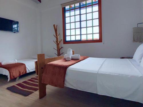 a bedroom with two beds and a window at Hotel Salento Mirador in Salento