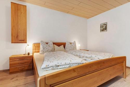 a bedroom with a large bed with a wooden headboard at Altes Forsthaus - Fewo Bianca in Bad Peterstal-Griesbach