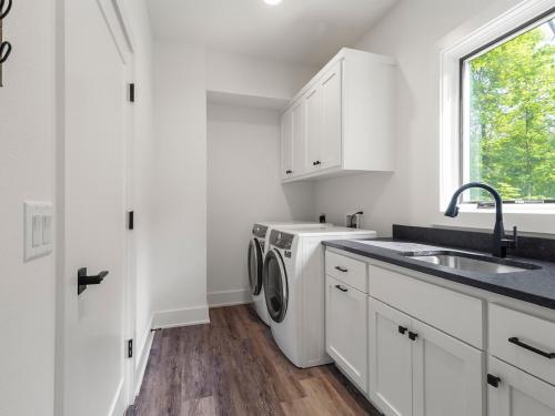 a white kitchen with a sink and a washing machine at Dirt Merchant Chalet Trail Access Hot Tub on Back 40 Trail in Bella Vista