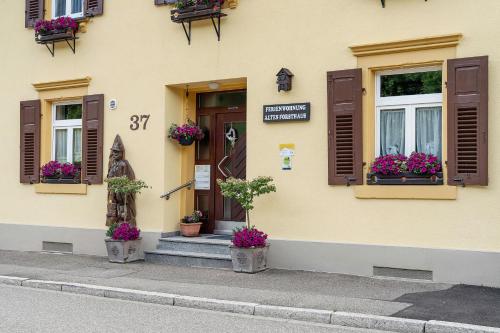 a building with windows and a statue in front of it at Altes Forsthaus - Fewo Bianca in Bad Peterstal-Griesbach
