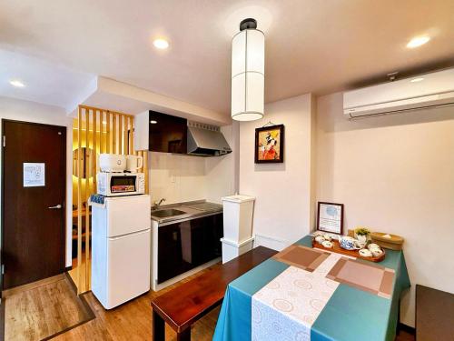 a small kitchen with a table and a refrigerator at 星宿川-竹の宿103 in Osaka