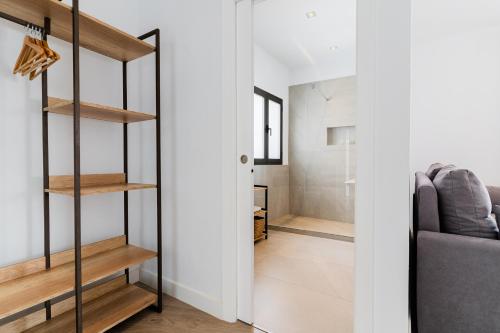 a living room with wooden shelves and a couch at Arena House Conil in Conil de la Frontera