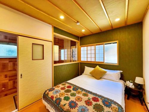 a bedroom with a bed and some windows at 星宿川-竹の宿103 in Osaka