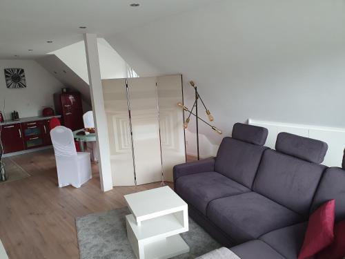 a living room with a purple couch and a table at Renoviertes Apartment in Troisdorf in Troisdorf