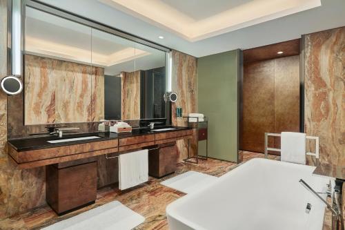 a bathroom with a sink and a mirror at Hilton Guangzhou Tianhe - Free Shuttle Bus and Registration Counter Available during Canton Fair Period in Guangzhou
