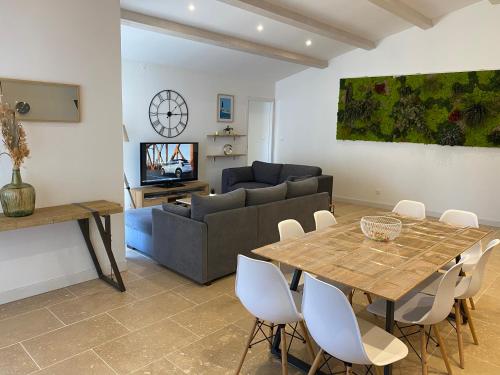 un salon avec une table et un canapé dans l'établissement Maison moderne plain-pied 3 chambres jardin préau, à La Rochelle