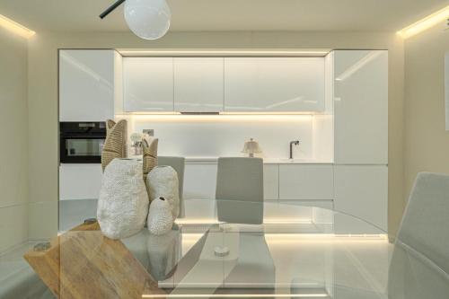 a kitchen with a glass table and chairs at Terrazza sul mare a Porto Cervo in Porto Cervo
