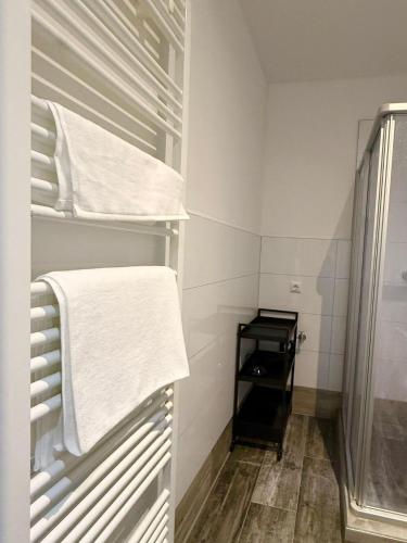 a small bathroom with white towels on a shelf at Hanse Vermietung 3 in Bremen