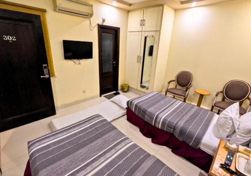 a hotel room with two beds and a tv at Panoramic Hotel Lahore in Lahore