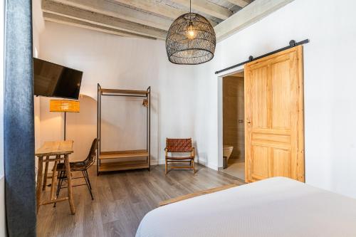 a bedroom with a bed and a table and a desk at Arena House Conil in Conil de la Frontera