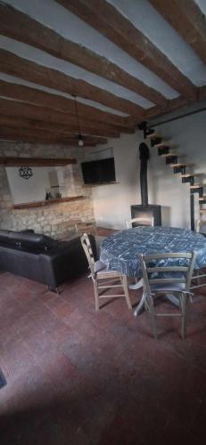 Cette chambre est dotée d'une table, de chaises et d'un mur en pierre. dans l'établissement Maison de vacances, à Varennes-sur-Loire
