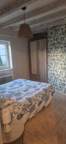 - une chambre avec un lit doté d'une couverture bleue dans l'établissement Maison de vacances, à Varennes-sur-Loire