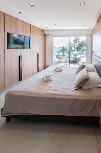 une chambre avec un grand lit avec une télévision à écran plat dans l'établissement T3 d'exception Croisette Cannes Vue Mer, à Cannes