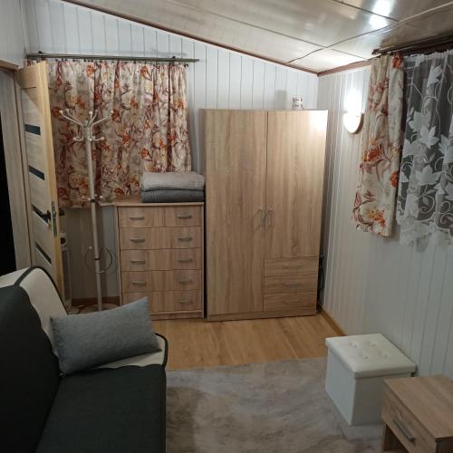 a living room with a cabinet and a couch at Domek02 Ośrodek Wypoczynkowy Joanna Wojnowo Lubuskie in Kargowa