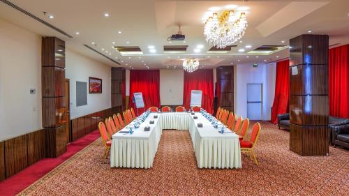 a large conference room with a long table and chairs at La Roche Hotel in Erbil
