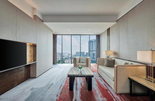 a living room with a couch and a tv at Hilton Guangzhou Tianhe - Free Shuttle Bus and Registration Counter Available during Canton Fair Period in Guangzhou