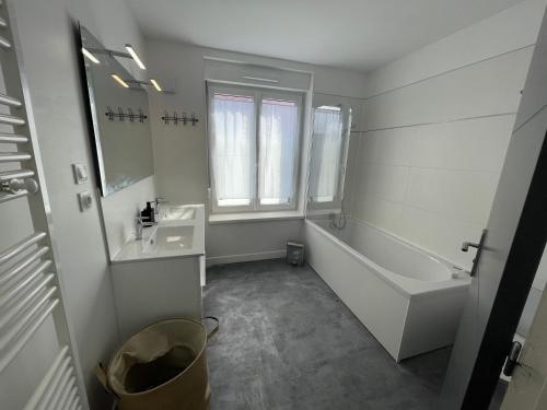 ein weißes Badezimmer mit einer Wanne, einem Waschbecken und einer Badewanne in der Unterkunft Le Duplex Marquettois - 3 chambres in Saint-André