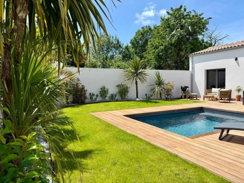 une cour avec une piscine et une clôture dans l'établissement Villa Palmeraie - Piscine, à Lagord