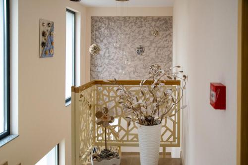 Un pasillo con un jarrón con flores. en Brizo Boutique Hotel, en Mamaia