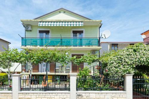 a house with a balcony on top of a fence at Apartments Grassi by Rent Istria in Umag