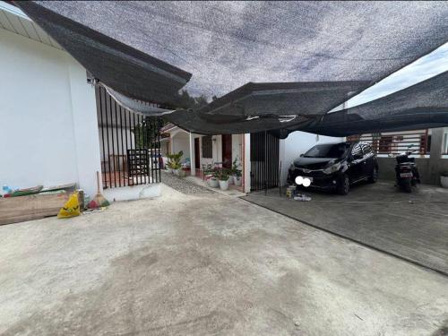 a garage with a car parked under a black covering at L&G Tourists Inn in Moalboal