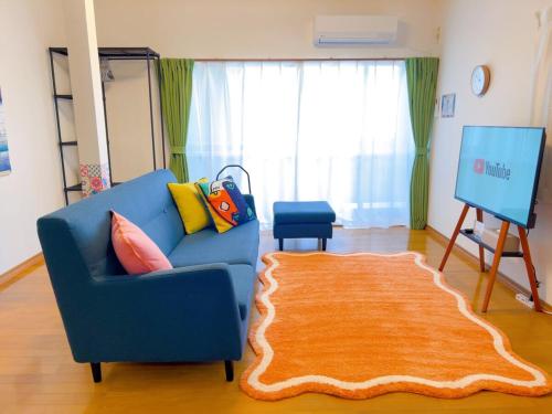 a living room with a blue couch and a rug at Stay Like a Local Hiroshima Hiroshima Station Entire House 1-6 ppl in Hiroshima
