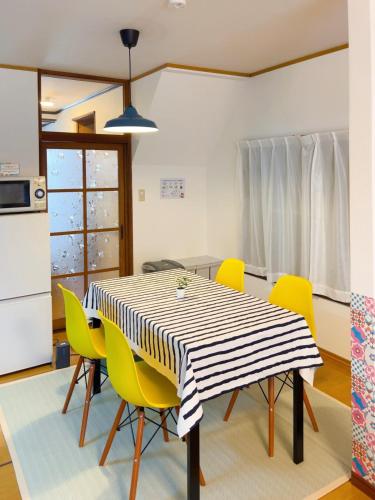 a dining room with a table and yellow chairs at Stay Like a Local Hiroshima Hiroshima Station Entire House 1-6 ppl in Hiroshima