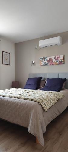 - une chambre avec un grand lit et des oreillers violets dans l'établissement Maison Balaguera, à Saint-Jean-de-Marsacq