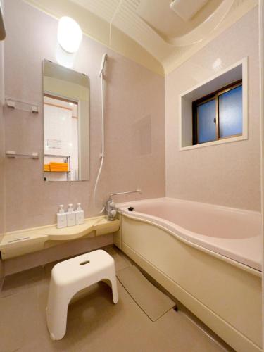a bathroom with a tub and a toilet and a sink at Stay Like a Local Hiroshima Hiroshima Station Entire House 1-6 ppl in Hiroshima