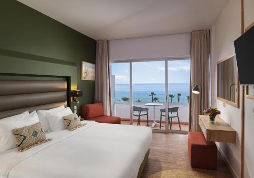 a hotel room with a bed and a view of the ocean at Leonardo Cypria Bay in Paphos