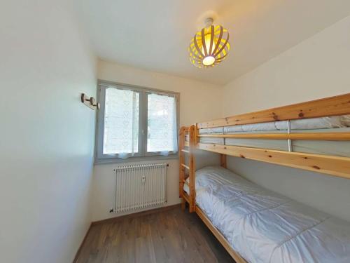 une chambre avec deux lits superposés et une fenêtre dans l'établissement Appartement 3 pièces, 7 couchages, Le Grand-Bornand - FR-1-241-203, au Grand-Bornand