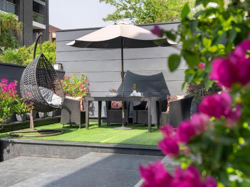 a patio with a table and chairs and an umbrella at The Atara Near Golf Course Road in Gurgaon