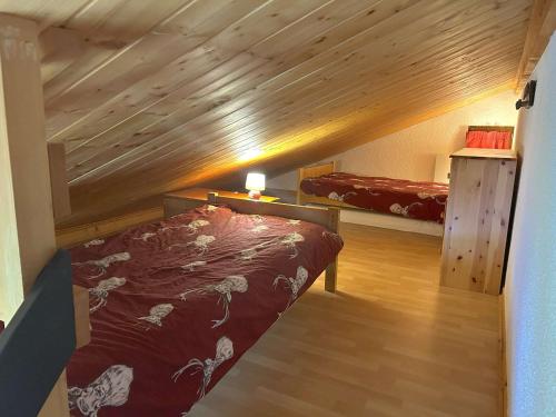 Cette chambre mansardée comprend un lit et un plafond en bois. dans l'établissement Studio cabine Les Saisies 6 pers, proche pistes, balcon sud/est - FR-1-594-188, à Hauteluce