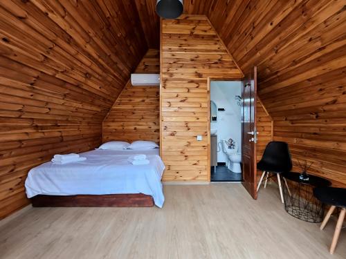 a bedroom with a bed in a wooden room at One & Kos Resort in Costinesti