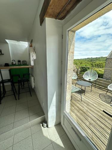 Cette chambre dispose d'une grande fenêtre et d'un balcon. dans l'établissement Le 16 du Bout du Monde, à Cléden-Cap-Sizun