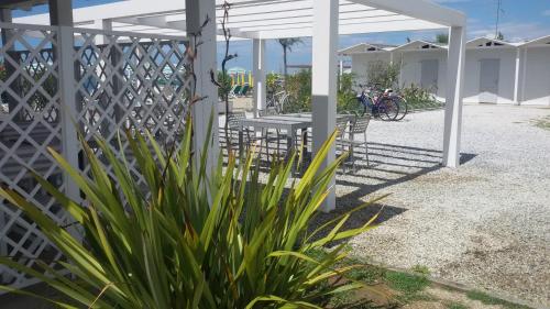 a white fence with a table and chairs on a patio at Hotel Marina in Marina di Massa