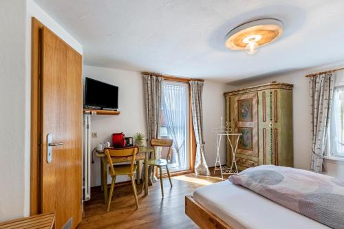 a bedroom with a bed and a table and chairs at Pension Ferienwohnung Baarblick in Donaueschingen