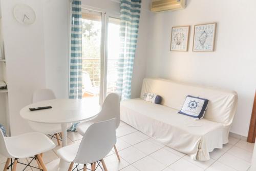 a white living room with a white table and chairs at Mola Kaliva Seaview Retreat in Mola Kalyva