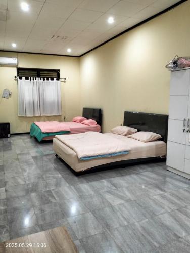 a room with three beds in it with at Kos di Menteng, Jakarta Pusat in Jakarta