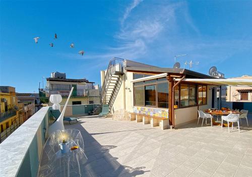 a balcony of a building with a table and chairs at Solemar Sicilia - Casa Enza in Santa Flavia