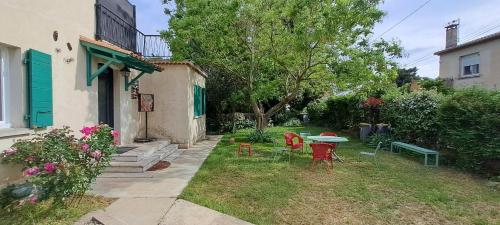 une arrière-cour avec une table, des chaises, une table et des chaises dans l'établissement Les loups blancs en Provence, à Pélissanne