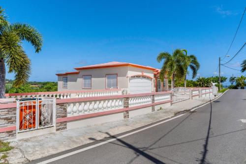 a house with a fence on the side of a road at Tropical Paradise in Rincon in Aguada